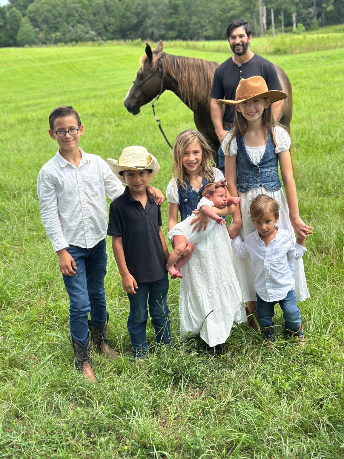 The Morgan family together in a pasture with a horse